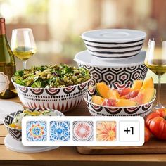 a table topped with plates and bowls filled with food next to wine glasses on top of a wooden table