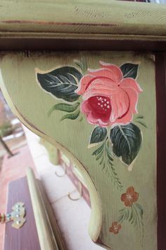 an ornate painted wooden shelf with flowers on it