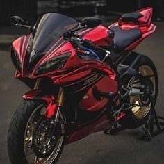 a red motorcycle parked on top of a parking lot