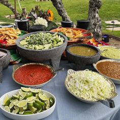 a table topped with bowls filled with different types of dips and condiments