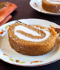 there is a piece of cake on the plate with icing and cinnamon sticks next to it