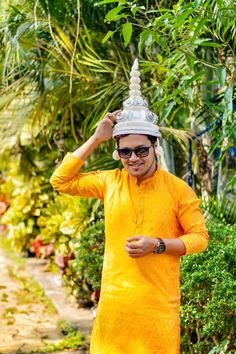 a man in an orange outfit is wearing a white hat and sunglasses on his head