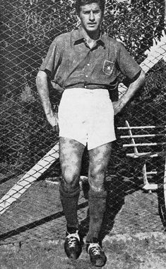 an old black and white photo of a man standing next to a tennis racket