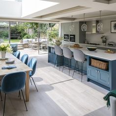 a kitchen with blue chairs and an island in the middle is seen from across the room