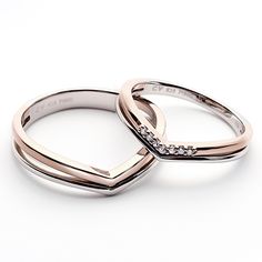 two white gold wedding rings with diamonds on top and the other one is in front