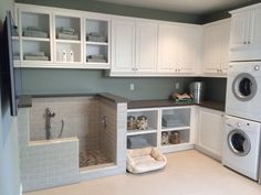 a laundry room with white cabinets and washer and dryer in the corner next to each other