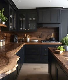 a wooden counter top in a kitchen next to black cupboards and counters with plants on it