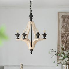 a wooden chandelier hanging from a ceiling in a living room with white walls