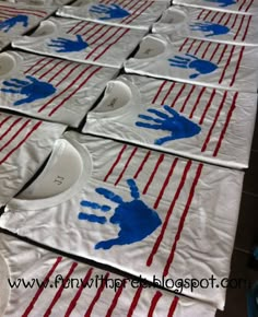 handprints on white table cloth with red and blue stripes are laid out in rows