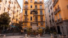 the building is yellow and has balconies on it