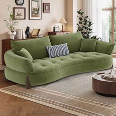 a living room with green couches and pictures on the wall