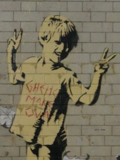 a wall that has graffiti on it with a boy holding his hand up in the air