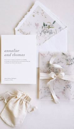 the wedding stationery is laid out on top of each other and tied with ribbon