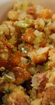 a bowl filled with stuffing and vegetables on top of a table