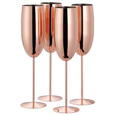 three rose gold wine glasses sitting next to each other