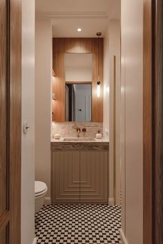 a bathroom with black and white checkered flooring next to a mirror on the wall