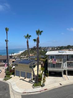 two houses with palm trees and the ocean in the background