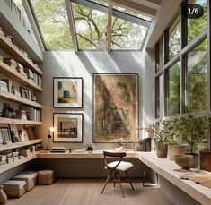 a home office with lots of bookshelves and pictures on the wall above it