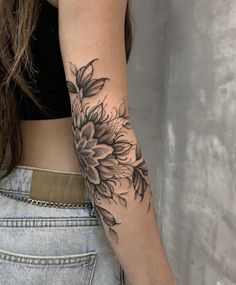 a woman with a sunflower tattoo on her left arm and the back of her right arm