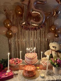 a table topped with lots of cakes and balloons