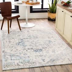 a large rug in the middle of a kitchen with a table and chairs next to it