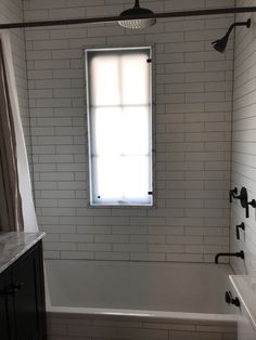 a bathroom with white tile and black fixtures