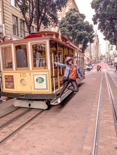 a trolley car with people on it going down the street