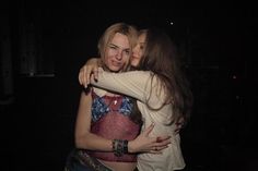 two women hugging each other in the dark