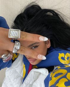 a woman laying on top of a couch with her hands covering her face and fingers