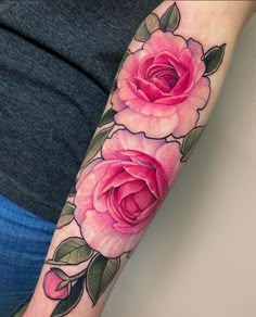 a woman's arm with two pink roses on it