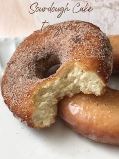 two sugar doughnuts with one bite taken out