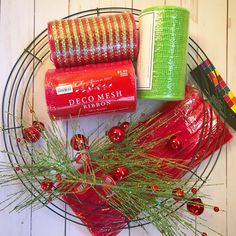 a wreath with red and green ribbons, tinsels, and other holiday decorations