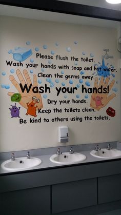 a bathroom with two sinks and a mural on the wall above them that says wash your hands