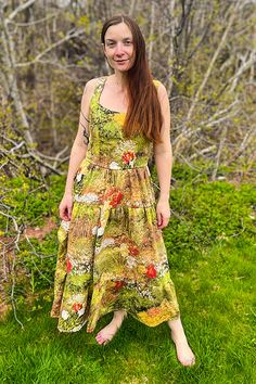 a woman standing in the grass wearing a dress