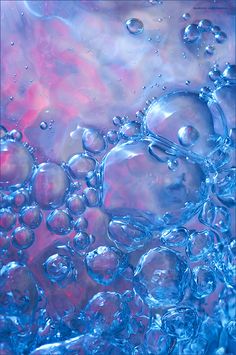 closeup of water bubbles in a blue glass container with red and white background,