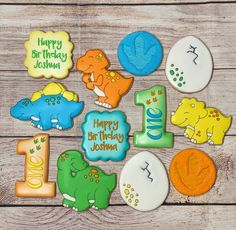 decorated cookies with the number one and dinosaurs for 1st birthday on a wooden table