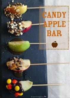 candy apple bar is displayed on a black slate platter with apples and candies