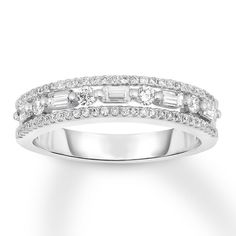 a white gold wedding band with baguettes and diamonds on the sides, set in 18k white gold