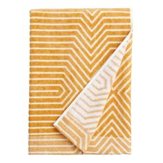 a yellow and white towel folded on top of each other with an orange chevron pattern