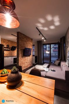 a living room filled with furniture and a flat screen tv mounted to a wall next to a window