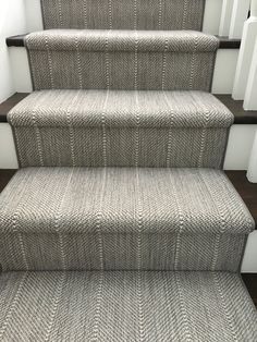 a carpeted stair runner on the bottom of a set of stairs