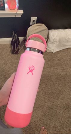 a person holding a pink water bottle in their hand