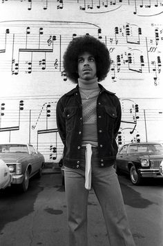 a man standing in front of a wall with musical notes on it's side