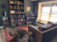 a living room filled with furniture and bookshelves next to a large open window