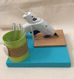 a toy airplane sitting on top of a table next to a cup and pen holder