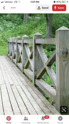 a wooden bridge in the middle of a forest with trees and grass on both sides