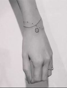 black and white photograph of a woman's hand with a flower tattoo on it