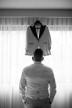 a man standing in front of a window with a suit on top of his head