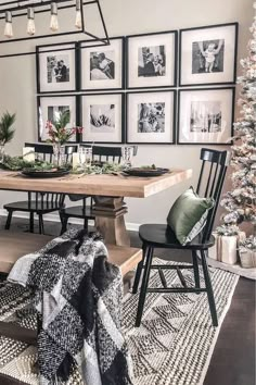 a dining room table with chairs and pictures on the wall above it, surrounded by christmas decorations