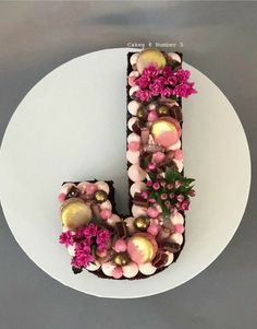 the letter j is made out of chocolate and decorated with candy eggs, flowers and leaves